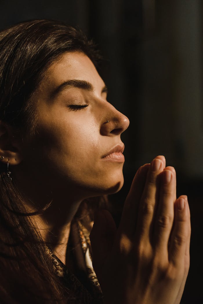 Mastering the First Impression: Your intriguing post title goes here A woman with eyes closed in prayer, conveying peace and introspection.